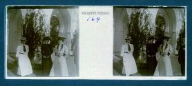 [Three unid. women and one man in courtyard]