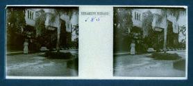 [Unid. woman and man standing outside of hotel]