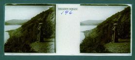 [Woman on cliff ledge looking at water]