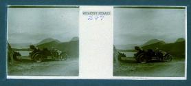 [Car on bluff overlooking mountains and water]