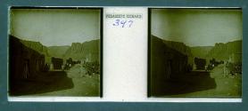 [View of desert buildings with people in street]