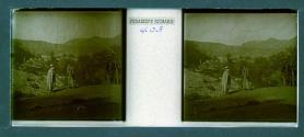 [Woman and guide with village in backround]