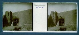 [Two men looking through ruins]