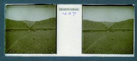 [Person on mule - village and mountains in backround]