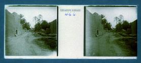 [People posing by stone buildings and dirt road]