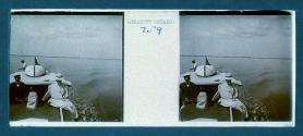 [Woman posing next to captain(?) of boat]