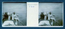 [Woman posing next to captain(?) of boat]