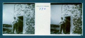 [Man posing by doorway of lighthouse]