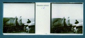 [Two unid. women and man on hill overlooking water]