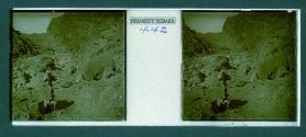 [Tourists and guides on path through mountains]