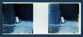 [Woman on bench by barn]