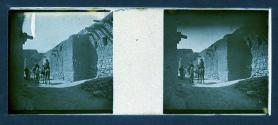 [Two women on mules on dirt road]
