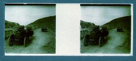 [Two cars on dirt road]