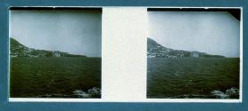 [View of water and village on hill]