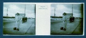 [Unid. woman on street holding suitcase - men in backround]