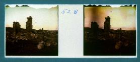 [Woman standing by ruins]