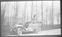 Woman standing in horseless carriage
