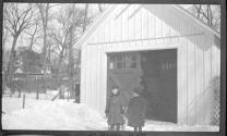 Two children in front of carriage house