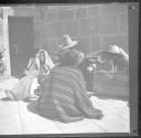 Family group sitting on sidewalk