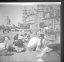 People sitting on ground in front of church