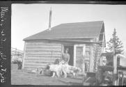 Man with dogs in front of camp, Alaska trip