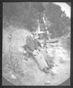 Man and woman sitting on hillside-probably trimmed, early roll