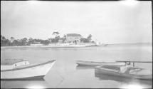 [Boats on river, large building on opposite shore]