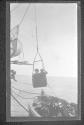 [People in basket transfering from ship to ship]