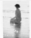 [Nude kneeling on beach]