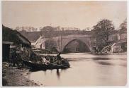 [Fishermen on a boat by bridge]