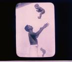 [man tossing baby up into air]