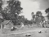 [Farmyard scene, people working]