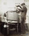 [Man pouring milk into separating machine]