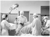 [Delivery room, doctor holding newborn baby]