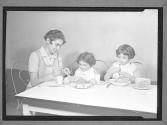[Woman, Two Children at a Meal]