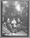 [Four people at an outdoor tea table]