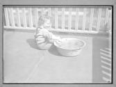 [Child on Porch next to Basin]