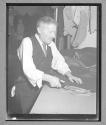 [Older Man Cutting Cloth]