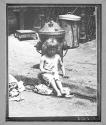 [Child Sitting by Fire Hydrant]