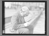 [Man Cleaning Nails on Bench]