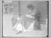 [Woman Asleep on Street Near Basket]