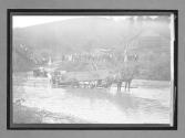 [wagon pulling auto from river]