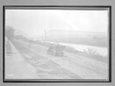 [auto driving by along river]
