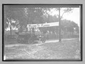 [auto tourist passing beneath sign "Welcome to Florida"]