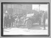 [auto tourists with spectators in town]