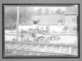 [two autos by railroad tracks]