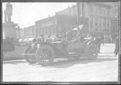 [auto tourists parked by monument in city]