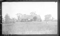 Girl in front of small farmhouse, Oak Lodge Trip