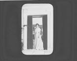 Woman standing in interior doorway