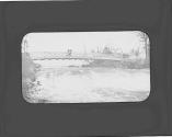 Women standing on bridge over rushing river